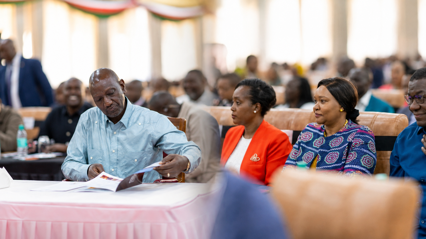 Government officials and delegates seated during the Broad Based Government Retreat in Naivasha, with participants reviewing documents and listening to proceedings.
